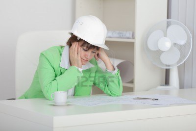 5814682-mujer-triste-el-ingeniero-con-un-casco-en-la-cabeza-se-sienta-en-una-mesa-en-un-lugar-de-trabajo